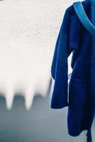 gros plan sur le jiu jitsu brésilien ou l'uniforme de kimono bleu judo suspendu à côté d'un mur photo