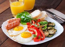 petit déjeuner anglais - œufs frits, saucisses, courgettes et poivrons doux photo