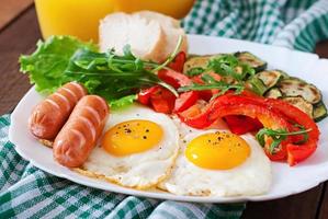 petit déjeuner anglais - œufs frits, saucisses, courgettes et poivrons doux photo