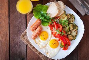 petit déjeuner anglais - œufs frits, saucisses, courgettes et poivrons doux photo