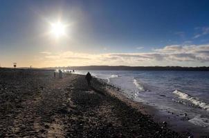 silhouettes de personnes parlant une promenade sur une plage ensoleillée de la mer baltique en allemagne. photo