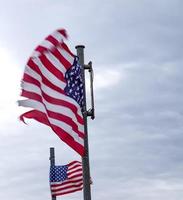 drapeau américain à un mât se déplaçant lentement dans le vent contre le ciel photo