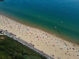 vue sur la mer à angle élevé devant la plage avec des gens à la ville de bournemouth en angleterre royaume-uni, images aériennes de l'océan britannique photo