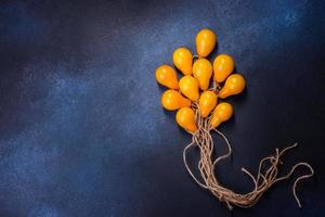 l'idée de concept sous forme de ballons sur des cordes est faite de tomates jaunes photo