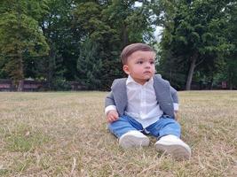 Mignon petit bébé bébé pose dans un parc public local de la ville de Luton en Angleterre Royaume-Uni photo