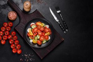 salade fraîche et délicieuse avec tomates cerises, concombres, poivrons, fromage et huile d'olive photo