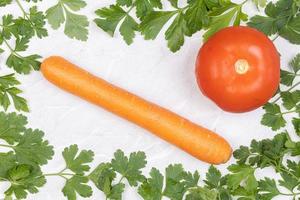 cadre de feuille de persil avec carotte et tomate au milieu photo