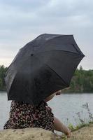 fille avec un parapluie par temps nuageux. photo