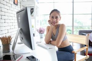 jeune femme asiatique utilisant un ordinateur portable vérifiant l'application de médias sociaux sur le site Web en ligne à la maison, se détendre et profiter de communiquer et de discuter dans le salon. photo