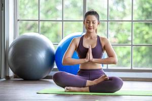 jeune femme asiatique travaillant et faisant du yoga à la maison, concept sain. photo