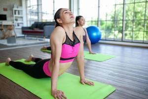 jeune femme asiatique travaillant et faisant du yoga dans la pose de cobra à la maison, concept sain. photo