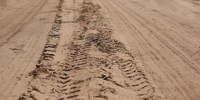 multiples traces de protecteurs de poids lourds sur le sable. photo