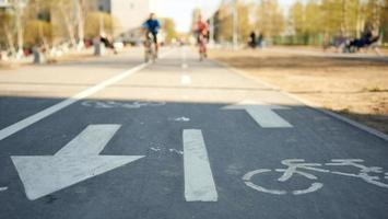 symbole de vélo sur la rue de la ville sur fond de cyclistes dans un flou. photo