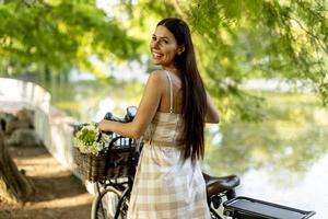 jeune femme avec des fleurs dans le panier de vélo électrique photo