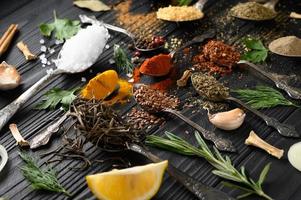 diverses herbes et épices colorées pour la cuisson sur fond rustique en bois foncé photo