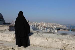 femme voilée musulmane regardant le paysage urbain d'istanbul photo