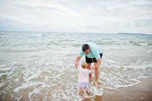 vacances d'été. activités de plein air des parents et des personnes avec des enfants. bonnes vacances en famille. père avec sa petite fille sur la plage de sable de mer. photo