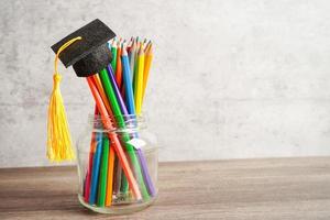 crayons colorés dans un bocal en verre avec espace de copie, apprentissage du concept d'enseignement universitaire. photo