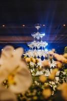 composition florale pour mariage d'été, faite de roses et de branches vertes sur une table de dîner au restaurant. , verre et assiettes dans le restaurant à l'extérieur par une journée venteuse avec effet de grain de film photo