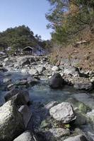 une rivière avec de l'eau chaude traverse la forêt à kusatsu onsen, japon photo