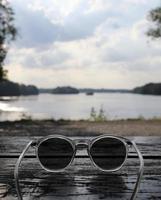 ciel magnifique au-dessus d'un lac vu au-dessus d'une paire de lunettes de soleil photo