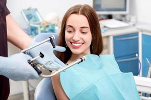 patiente de jeune femme visitant le dentiste dans le cabinet dentaire photo