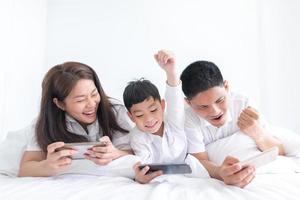 portrait famille heureuse maman papa et fils souriant dans la chambre à coucher. se regarder. photo