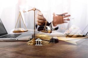 concept de justice et de droit. juge masculin dans une salle d'audience avec le marteau, travaillant avec, clavier d'ordinateur et d'accueil, lunettes, sur table à la lumière du matin photo