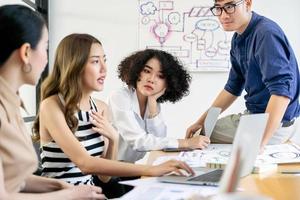 groupe de jeunes gens d'affaires créatifs asiatiques sérieux réunion d'équipe dans un bureau moderne planifiant et partageant des idées photo