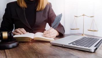 concept de justice et de droit. juge masculin dans une salle d'audience avec le marteau, travaillant avec, clavier d'ordinateur et d'accueil, lunettes, sur table à la lumière du matin photo