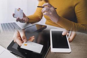 mains tenant une carte de crédit et utilisant un ordinateur portable. shopping en ligne