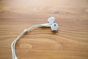 écouteurs audio blancs sur une table en bois photo