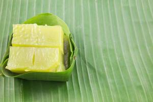 sorte de sucrerie thaïlandaise, gâteau sucré multicouche kanom chan sur feuille de bananier avec fleur d'orchidée photo