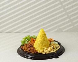 petit riz jaune en forme de cône ou tumpeng mini nasi kuning. nourriture festive indonésienne pour le jour de l'indépendance de l'indonésie photo