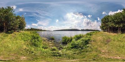 panorama hdri sphérique harmonieux à 360 degrés sur la côte herbeuse d'une immense rivière ou d'un lac par une journée d'été ensoleillée et par temps venteux en projection équirectangulaire avec zénith et nadir, contenu vr ar photo