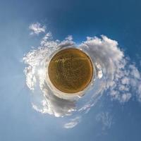 transformation de la petite planète du panorama sphérique à 360 degrés. vue aérienne abstraite sphérique dans le champ avec de beaux nuages impressionnants. courbure de l'espace. photo