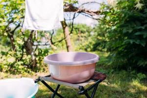 laver les vêtements à la main dans un bassin à l'extérieur en été photo