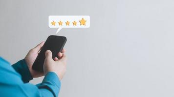 le concept d'enquête de satisfaction examine l'évaluation de la qualité des clients, l'évaluation des clients sur smartphone, l'évaluation des services ou des produits, l'évaluation 5 étoiles. photo
