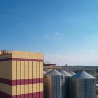 silo agricole. stockage et séchage des céréales, blé, maïs, soja, contre le ciel bleu avec des nuages. photo