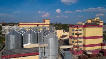 silo agricole. stockage et séchage des céréales, blé, maïs, soja, contre le ciel bleu avec des nuages. photo