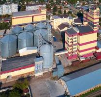 silo agricole. stockage et séchage des céréales, blé, maïs, soja, contre le ciel bleu avec des nuages. photo