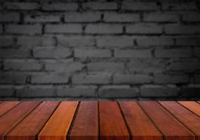 mise au point sélectionnée table en bois marron vide et texture de mur ou vieux mur de briques noires image d'arrière-plan flou. pour votre photomontage ou présentation de produit photo