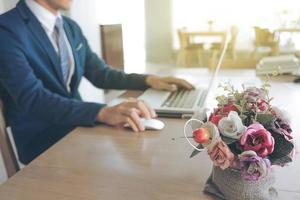 jeune homme travaillant avec un ordinateur portable sur son bureau dans un café, les mains de l'homme sur un ordinateur portable, un homme d'affaires sur le lieu de travail. photo