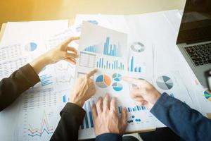 concept de réunion de l'équipe d'analyse marketing. équipage de jeune homme d'affaires travaillant avec un nouveau projet de démarrage dans un studio moderne et un ordinateur portable sur une table en bois. photo