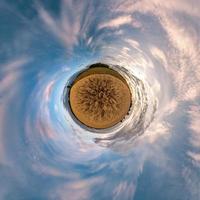 transformation de la petite planète du panorama sphérique à 360 degrés. vue aérienne abstraite sphérique dans le champ dans une belle soirée avec de beaux nuages impressionnants. courbure de l'espace. photo