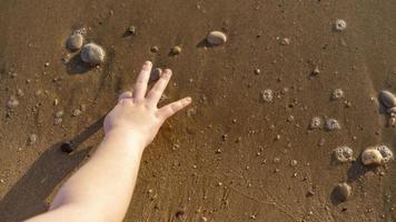 la main d'un homme sur fond de plage de sable photo