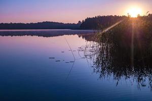 panorama sur un immense lac ou une rivière avec réflexion le matin avec un beau lever de soleil rose impressionnant photo