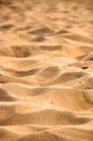 texture de fond de sable jaune sur la plage de la mer photo