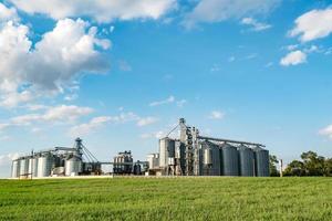 ascenseur à grenier. agro-industrie et usine de fabrication pour la transformation et les silos d'argent pour le nettoyage à sec et le stockage des produits agricoles, de la farine, des céréales et des grains. photo