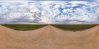 panorama hdri sphérique complet et harmonieux vue d'angle à 360 degrés sur la route de gravier parmi les champs en automne avec de beaux nuages en projection équirectangulaire, prêt pour le contenu de réalité virtuelle vr ar photo
